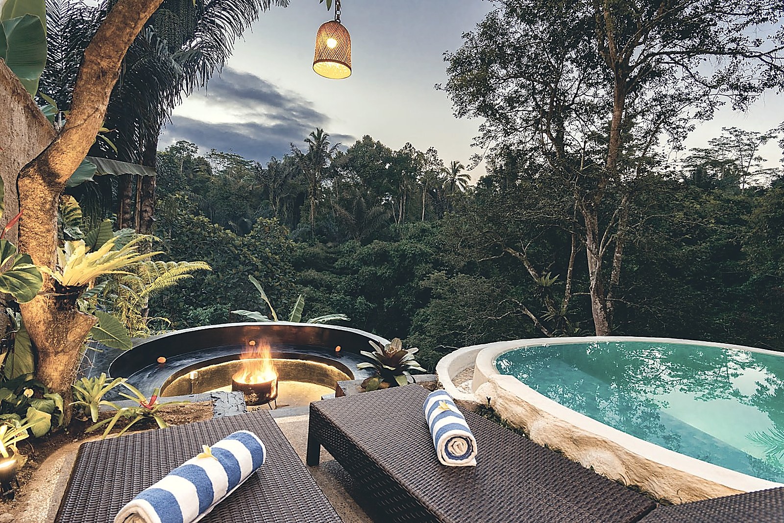 Pool and fire pit overlooking the jungle at dusk