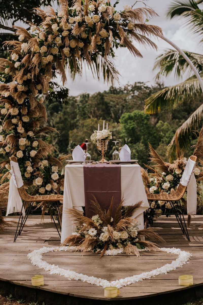 Dinner table for two on the deck, with a heart of petals and candles